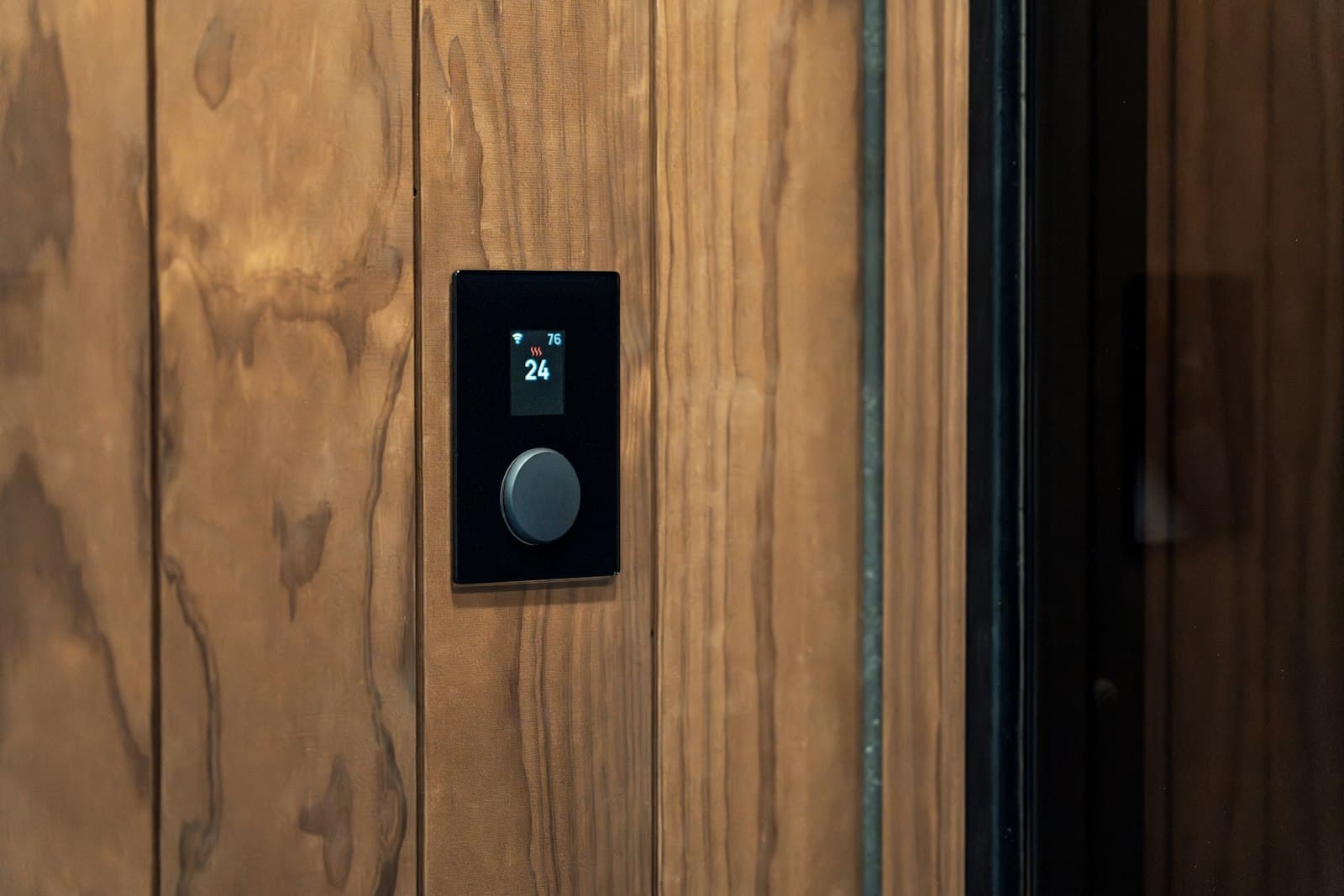 A keypad smart lock set into a dark wood front door.