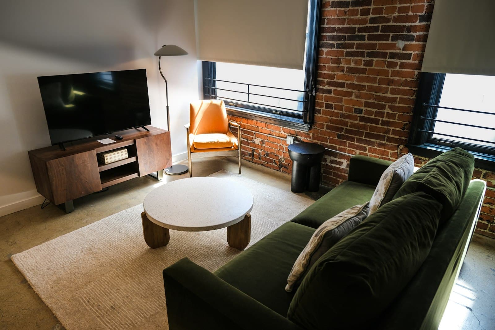 A loft living room with exposed brick and tall industrial windows.