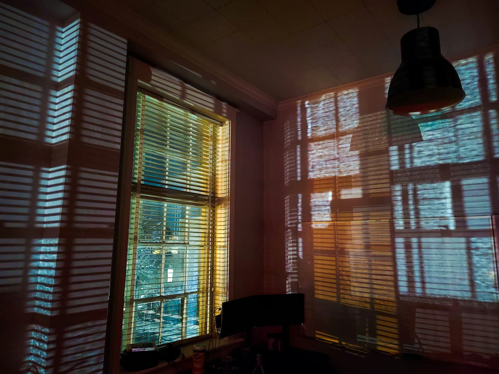 Evening light through the shutters of tall parlor-floor windows.