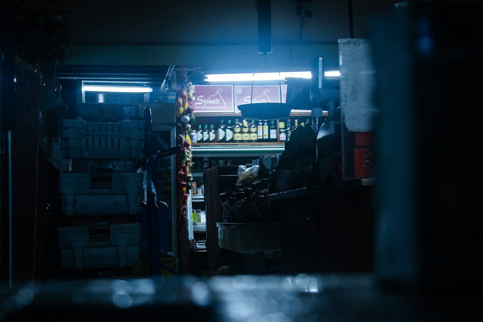 Shelves of stock in a dim back room lit by a single strip light.